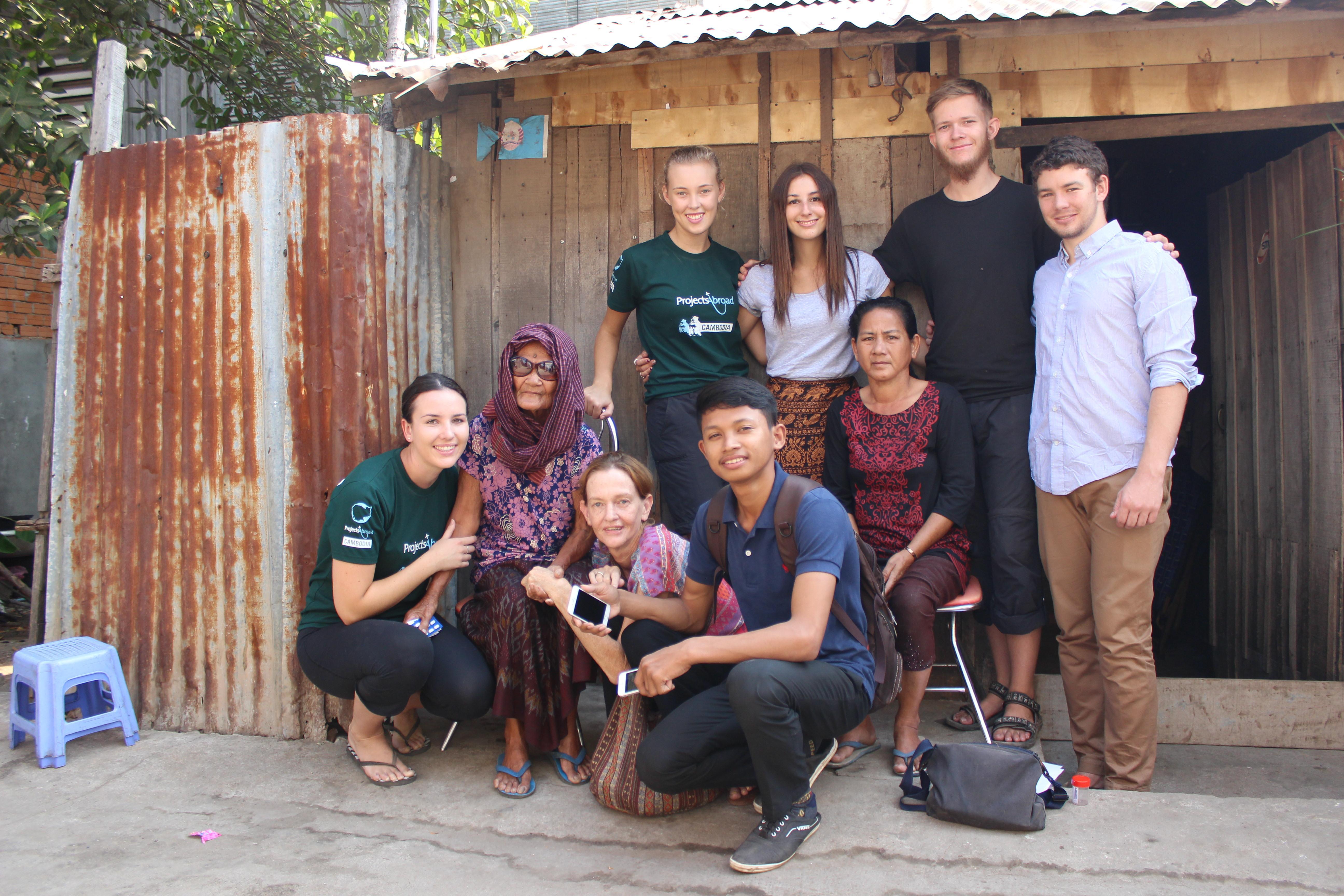 Volunteers take a group photo with a local family during their time abroad