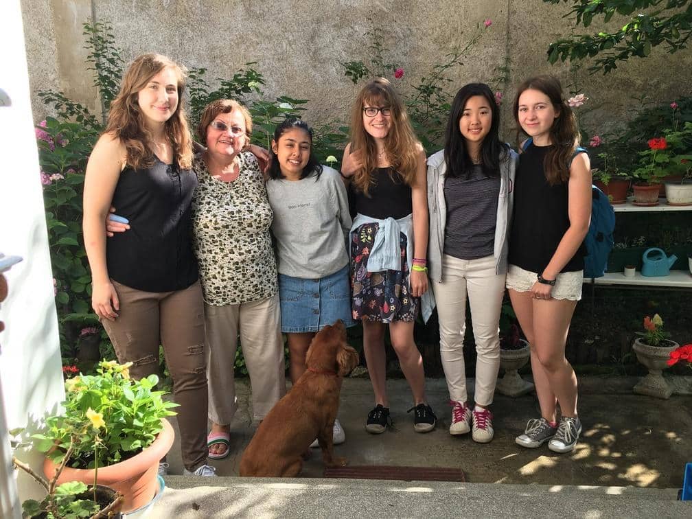 Projects Abroad volunteers take a group photo with their host mother in Romania.