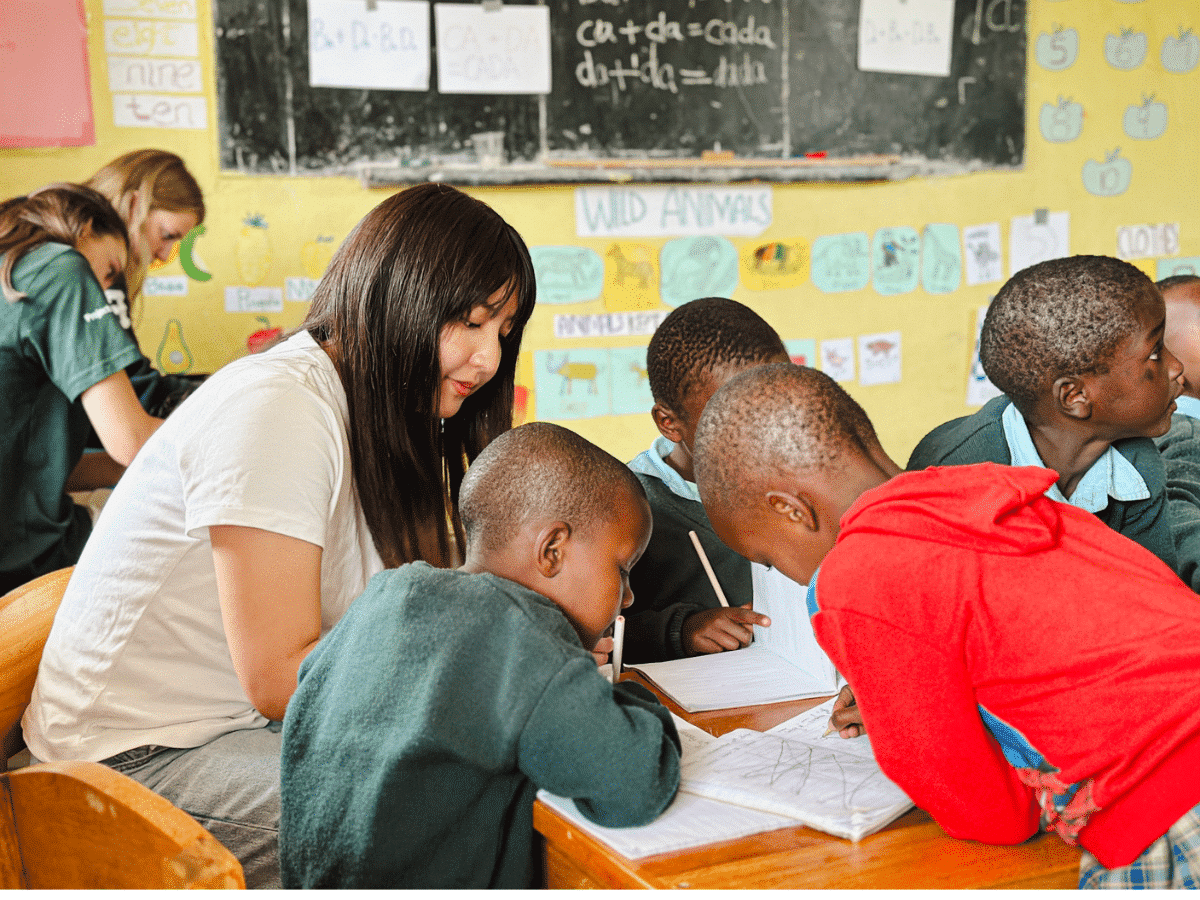 Maasai school Volunteer helping the children with school-work.