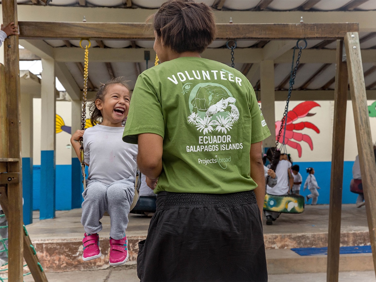 Volunteer and Child on Swing in Galapagos