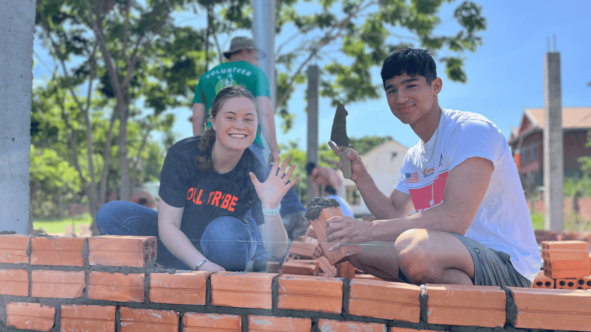 Two Projects Abroad volunteers lay bricks to help with construction work in Cambodia