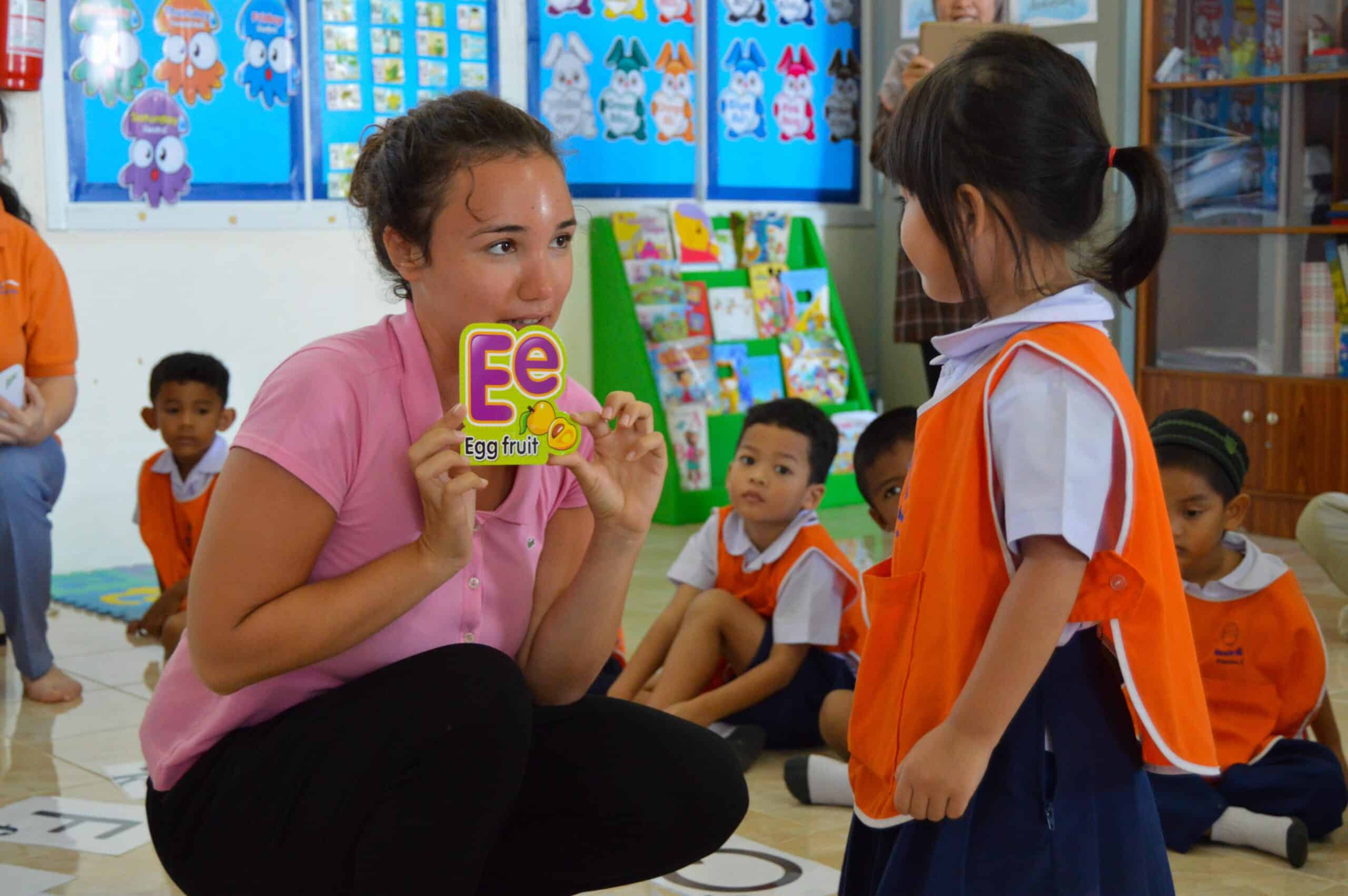 A volunteer teaches the alphabet to children at her Projects Abroad placement where no experience is needed to volunteer overseas.
