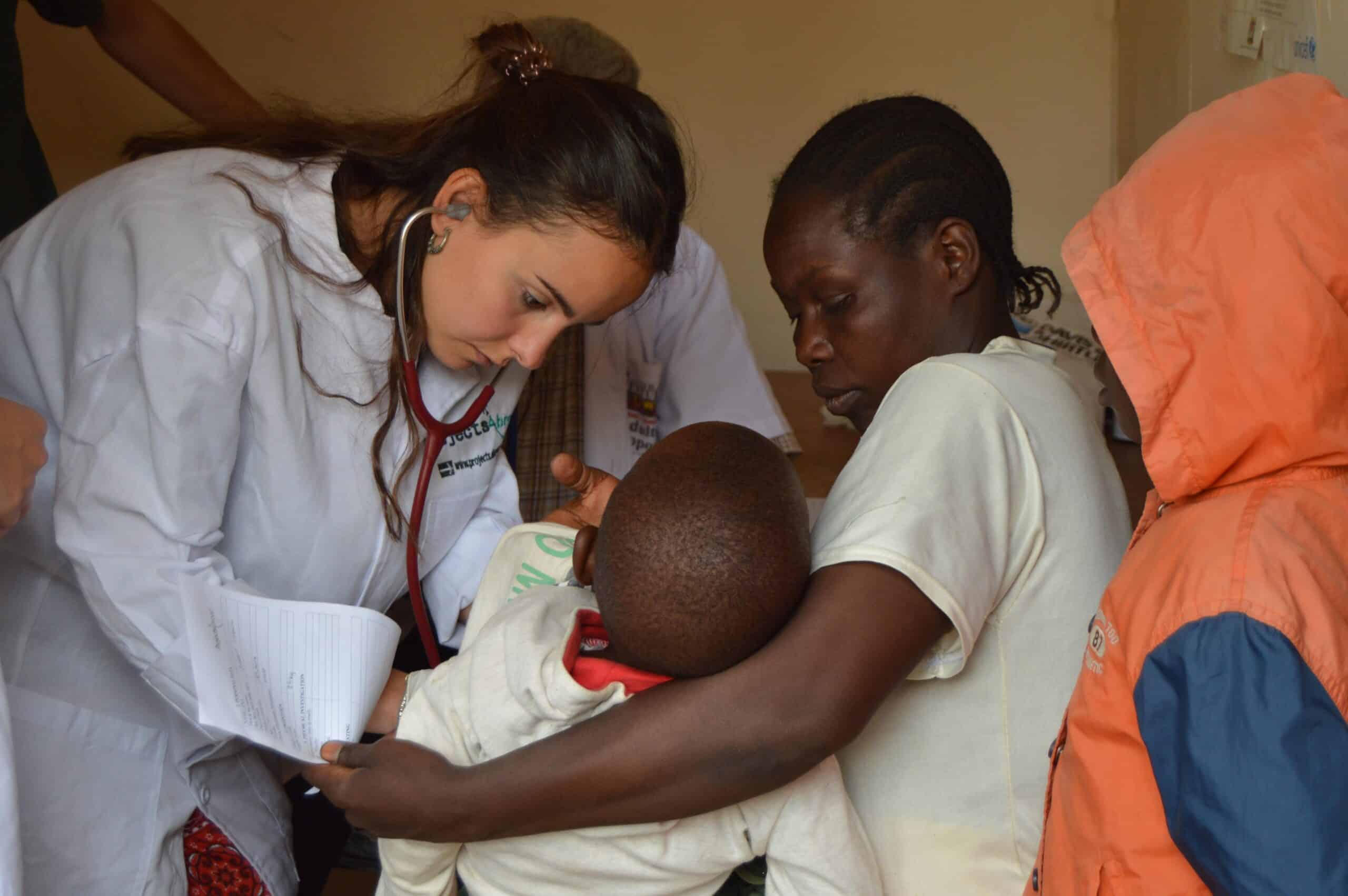 On a summer opportunity for medical students abroad, a Tanzanian child is examined by an elective student