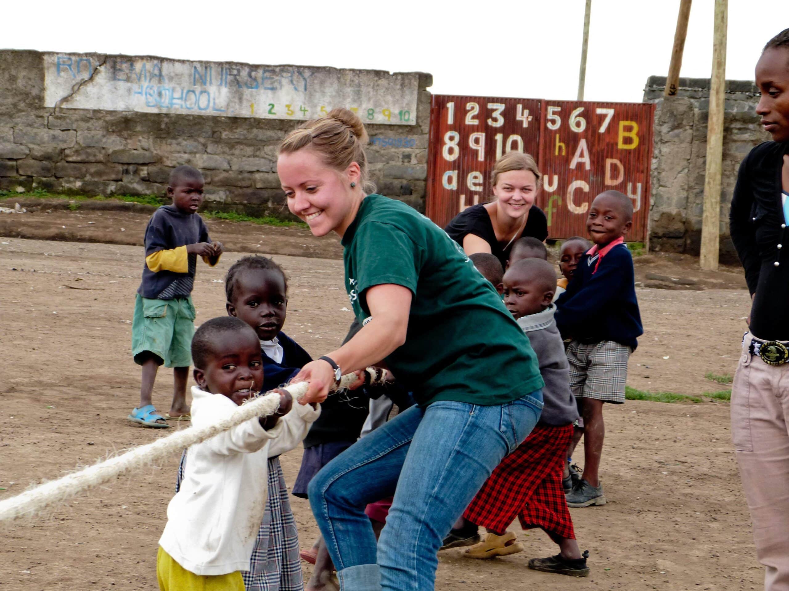 Volunteers working with children in Ghana teaches them teamwork with a fun activity.