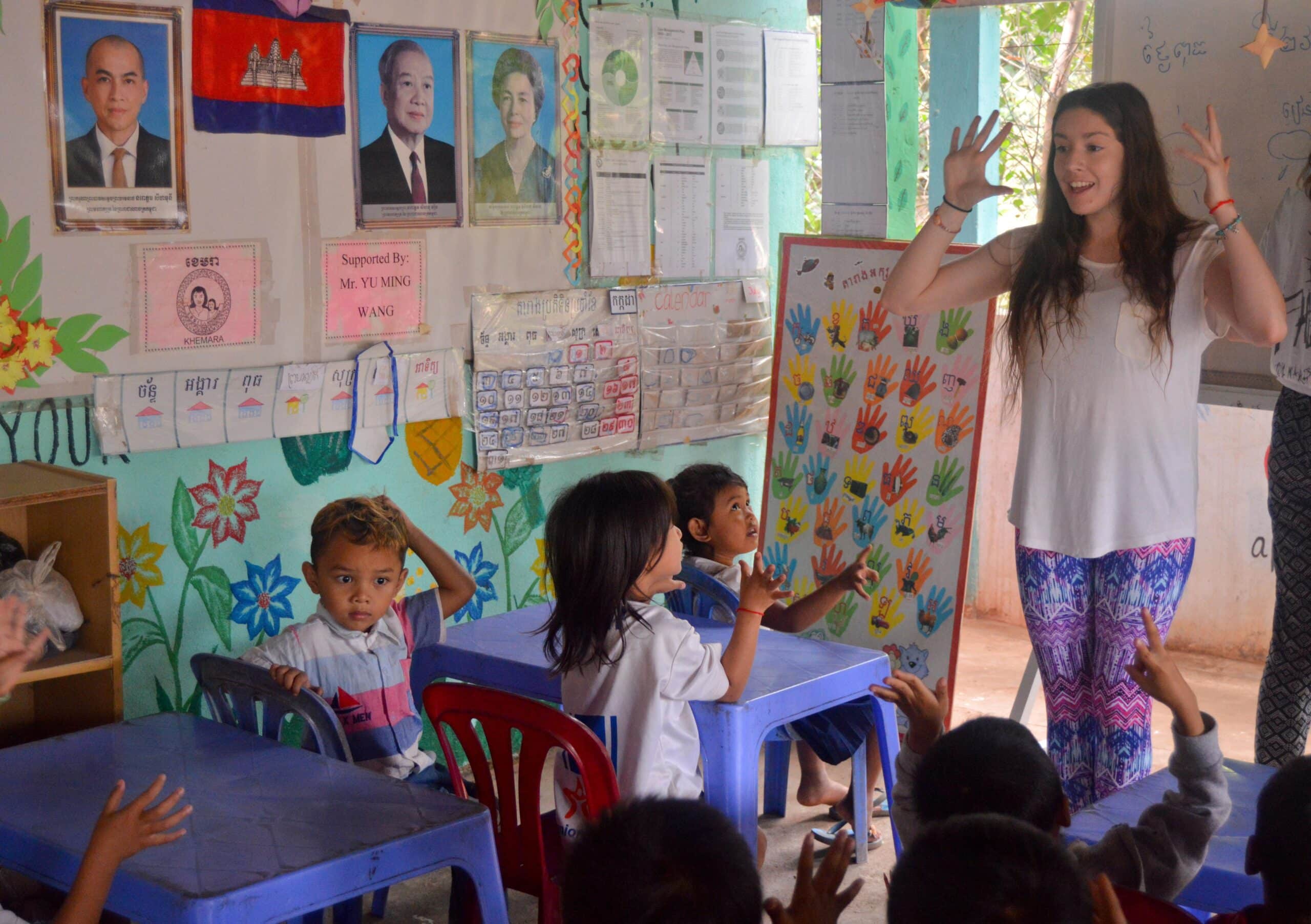 A High School Special Volunteer is teaching English words to the local children at the care & community placement during her volunteering trip in Cambodia.