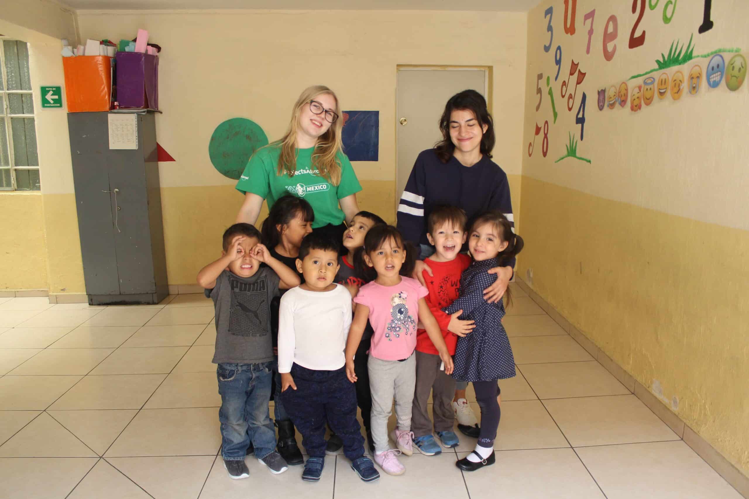 Group photo with volunteer and staff taking care of children.