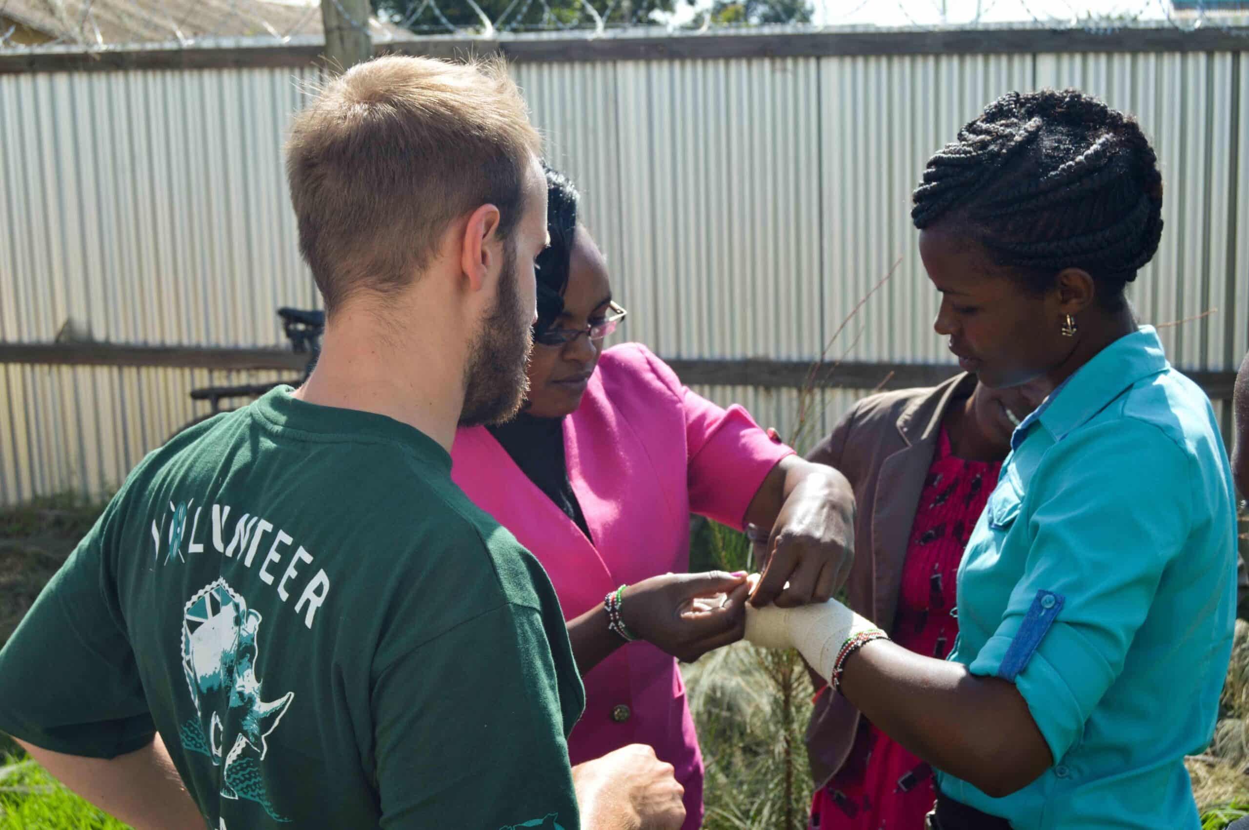 A Projects Abroad medical volunteer learns the correct way to put a bandage from a local doctor in Kenya.