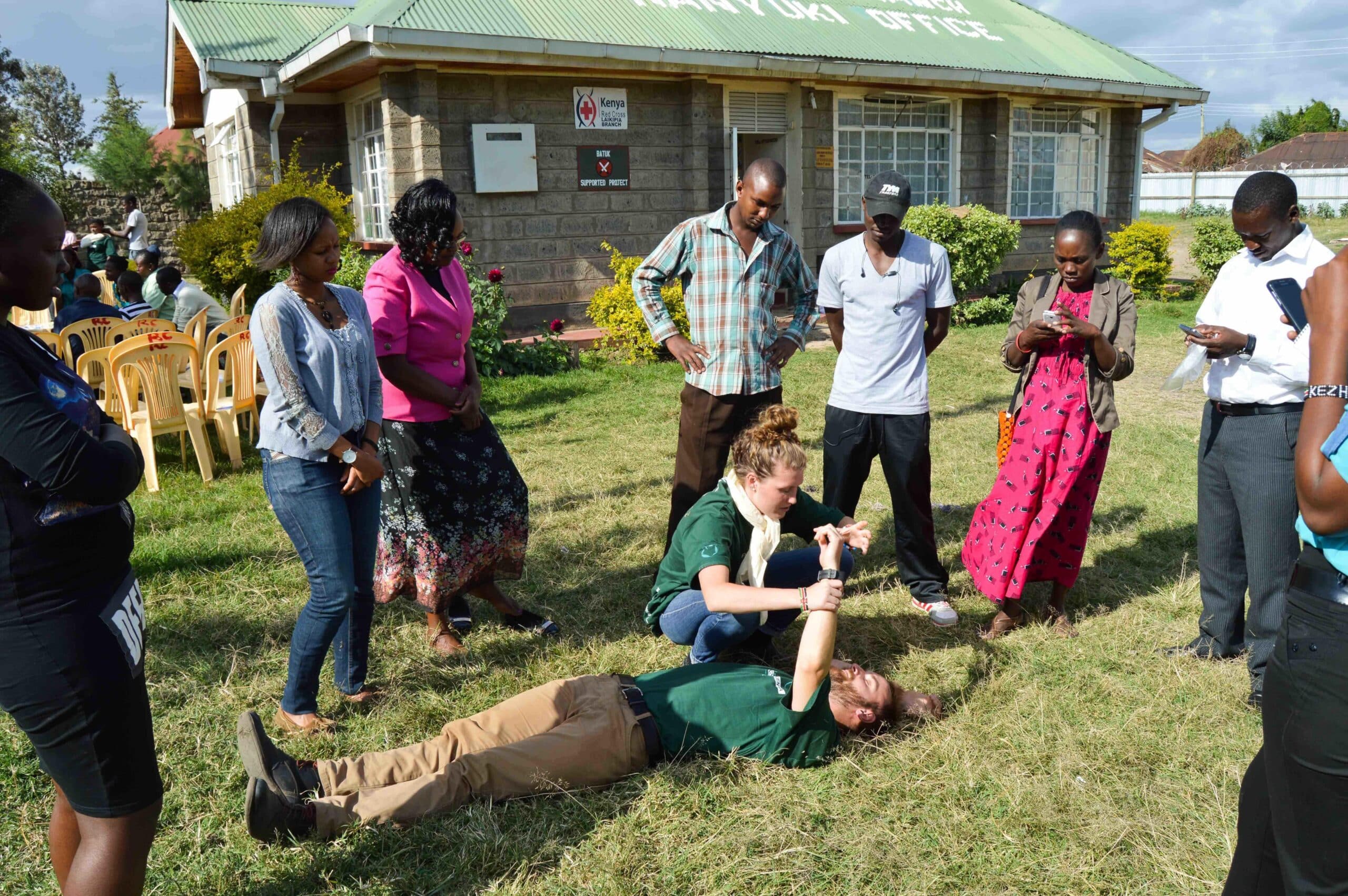 A couple of Projects Abroad medical volunteers teach some first aid techniques to local people in Kenya during a medical outreach.