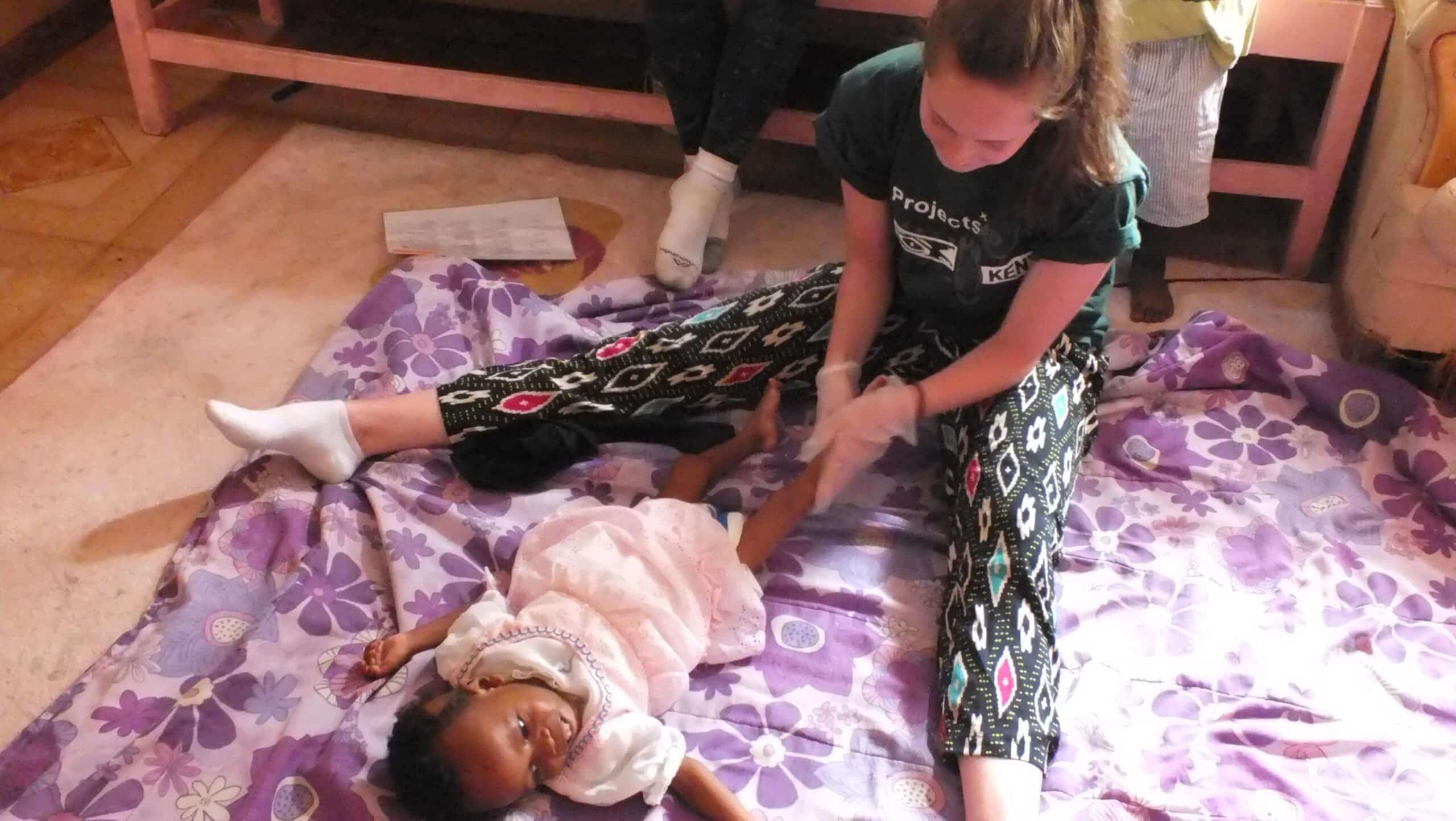 A Projects Abroad volunteer doing an Occupational Therapy internship in Kenya works on a baby's routine.