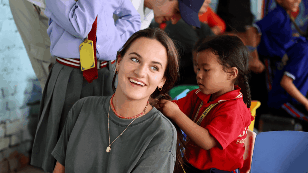 A child braiding a volunteer's hair in Nepal